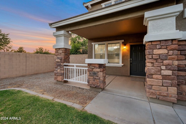 exterior entry at dusk featuring covered porch