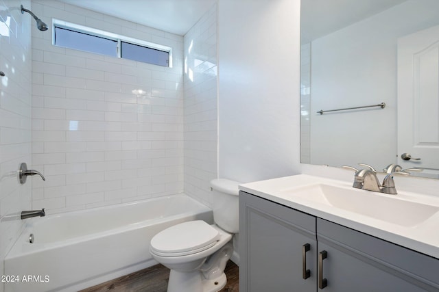 full bathroom featuring hardwood / wood-style floors, vanity, toilet, and tiled shower / bath