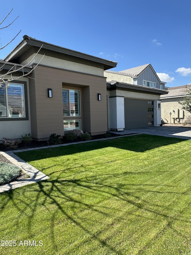 view of front facade with driveway, a garage, and a front lawn