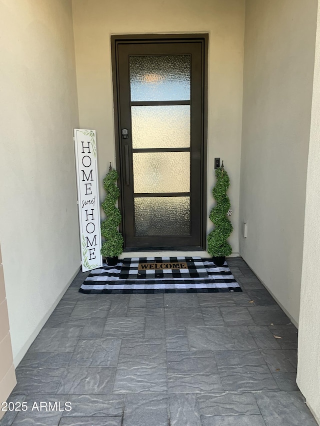 entrance to property featuring stucco siding