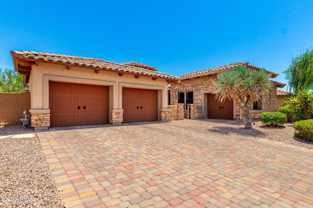 4041 N Silver Ridge Cir, Mesa, AZ 85207 - mediterranean / spanish home featuring stone siding, an attached garage, a tiled roof, stucco siding, and driveway
