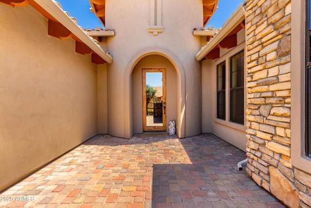 4041 N Silver Ridge Cir, Mesa, AZ 85207 - view of exterior entry featuring stucco siding, a patio area, stone siding, and a tile roof