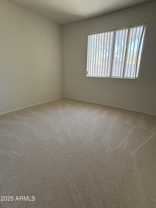 carpeted empty room with baseboards