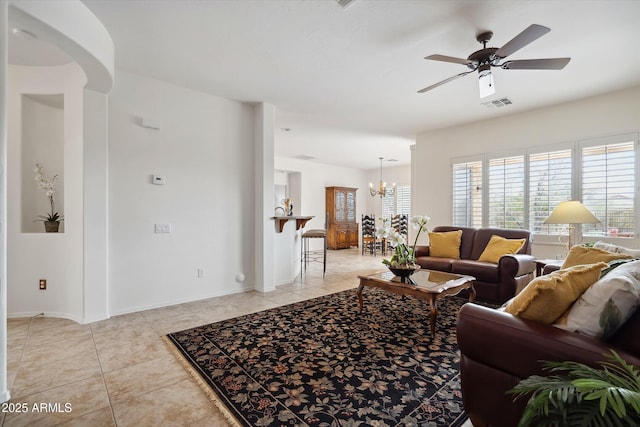 living room featuring light tile patterned floors and ceiling fan with notable chandelier