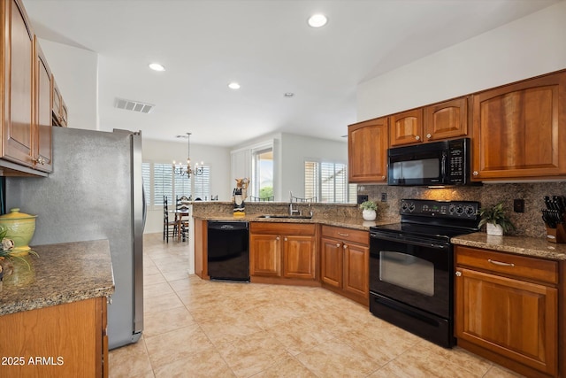 kitchen featuring tasteful backsplash, decorative light fixtures, sink, and black appliances