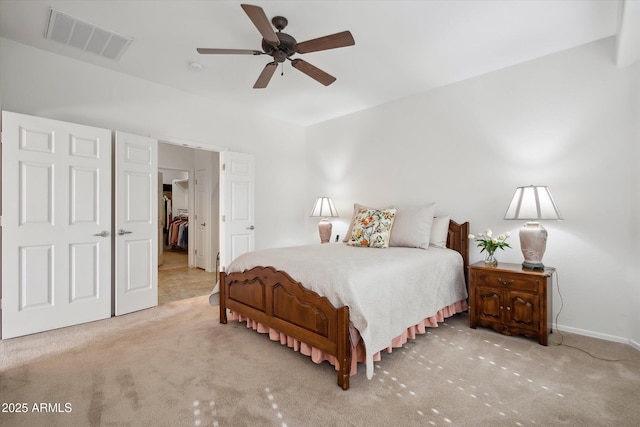 carpeted bedroom featuring ceiling fan, a walk in closet, and a closet