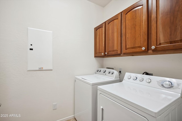 laundry room featuring cabinets, electric panel, and separate washer and dryer