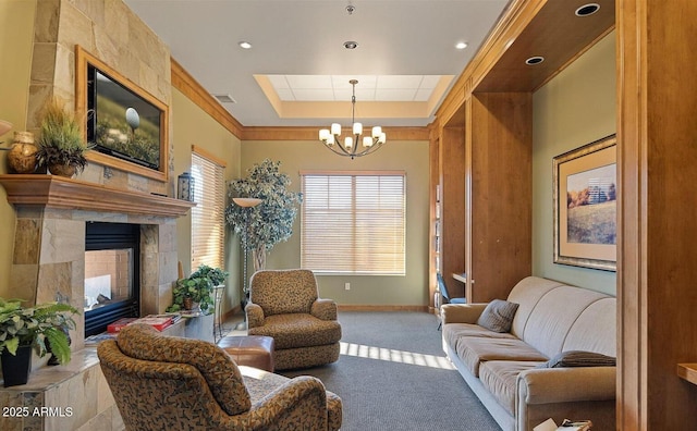 sitting room with an inviting chandelier, light colored carpet, a high end fireplace, and a tray ceiling