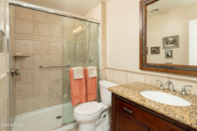 bathroom with tile walls, backsplash, walk in shower, toilet, and vanity