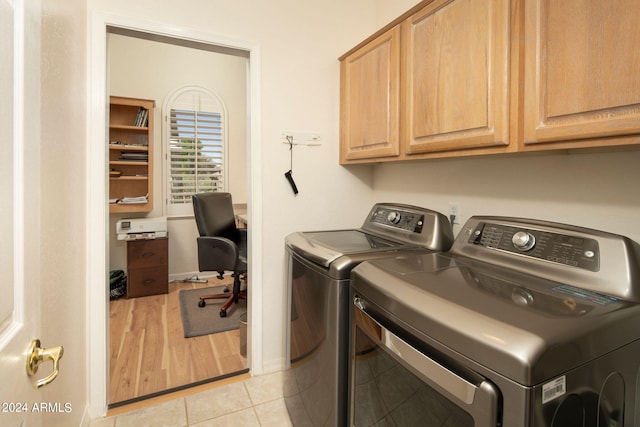 laundry area featuring independent washer and dryer, cabinets, and light tile floors