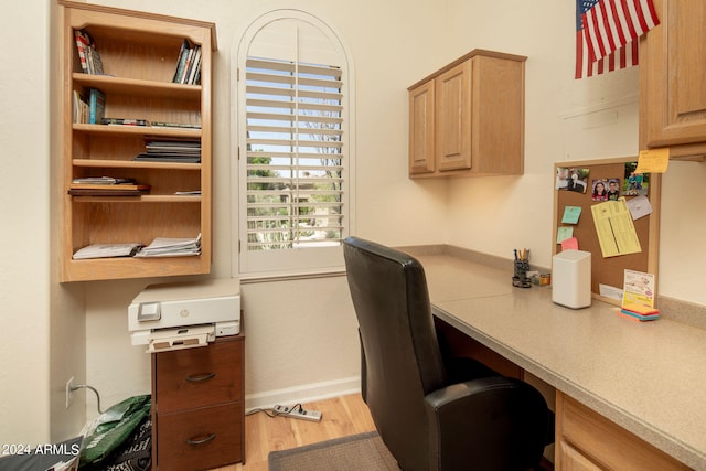 office featuring built in desk and light wood-type flooring