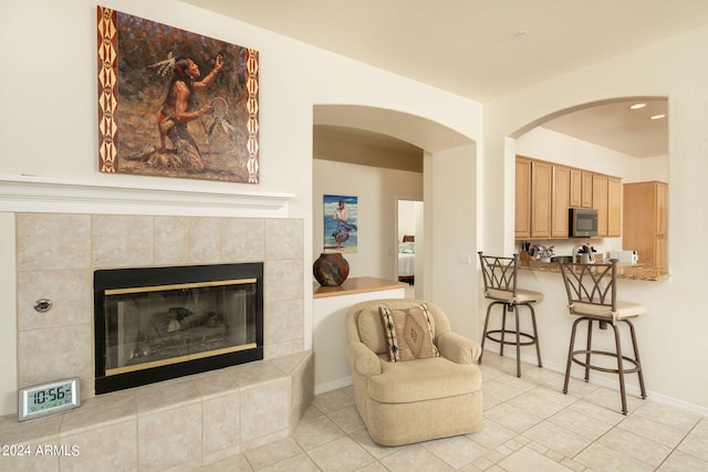 living room featuring a tile fireplace and light tile flooring