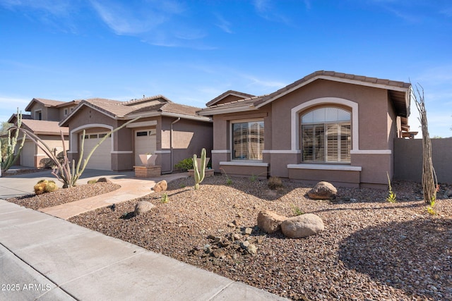 view of front of home with stucco siding, an attached garage, a tile roof, and concrete driveway