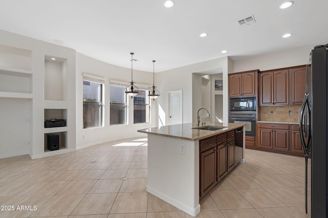 kitchen with a sink, built in features, light tile patterned floors, visible vents, and black appliances
