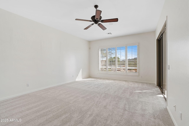 spare room with light carpet, baseboards, visible vents, and ceiling fan