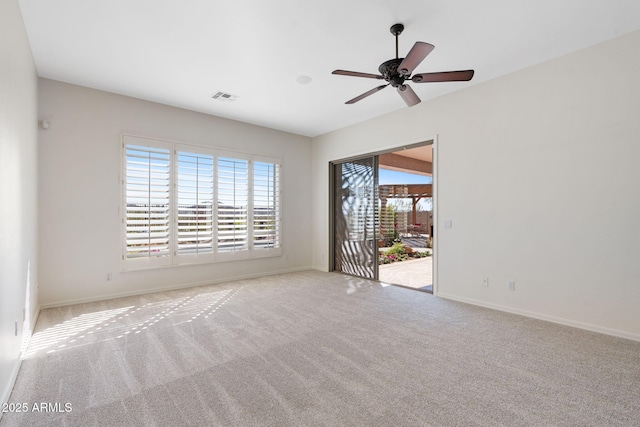 carpeted spare room featuring a wealth of natural light, baseboards, and visible vents