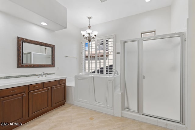 full bathroom featuring a chandelier, tile patterned floors, vanity, a stall shower, and a garden tub
