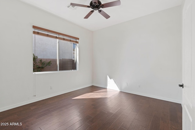 spare room featuring baseboards, visible vents, wood finished floors, and ceiling fan