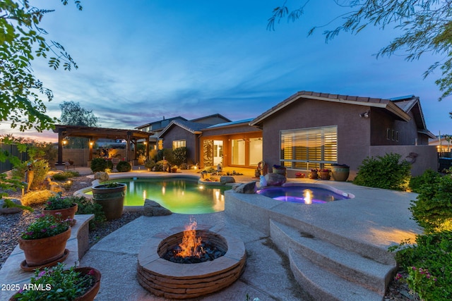 pool at dusk featuring a fenced backyard, a fire pit, an in ground hot tub, and a patio