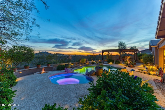 pool at dusk with an outdoor pool, a patio, a fenced backyard, a pergola, and an in ground hot tub
