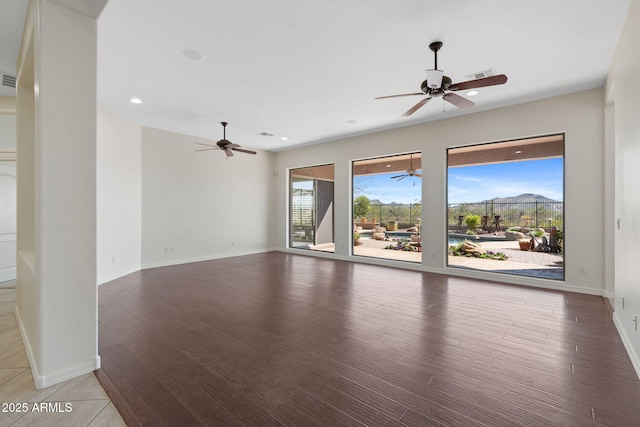 unfurnished room with a ceiling fan, plenty of natural light, and visible vents