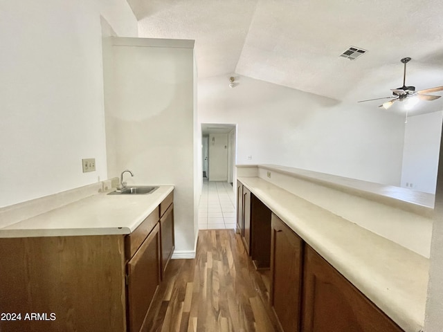 kitchen with ceiling fan, dark hardwood / wood-style flooring, lofted ceiling, and sink