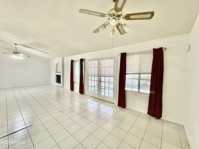 tiled spare room featuring french doors, a textured ceiling, ceiling fan, and lofted ceiling