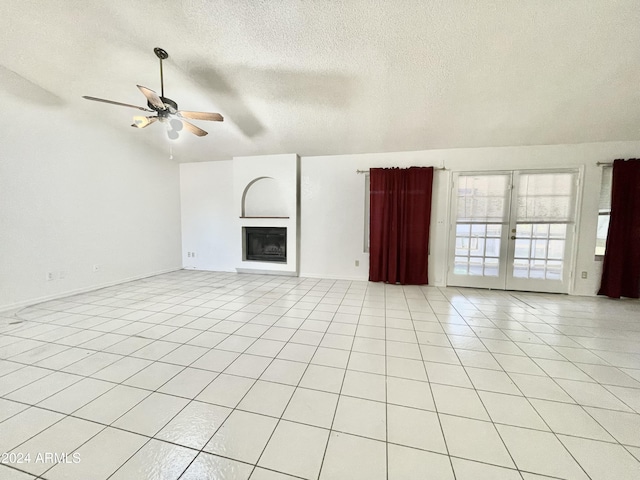 unfurnished living room with ceiling fan, french doors, light tile patterned floors, and a textured ceiling