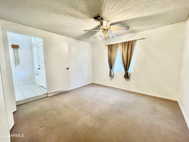 spare room featuring ceiling fan, carpet floors, and a textured ceiling