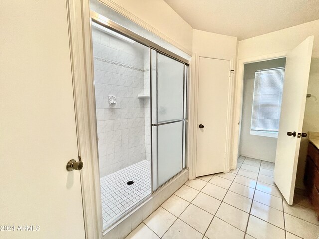 bathroom with tile patterned floors and a shower with door