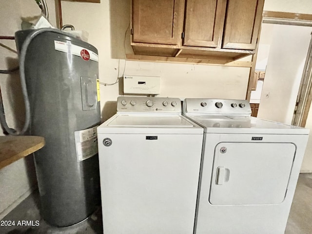 clothes washing area with water heater, cabinets, and washer and dryer