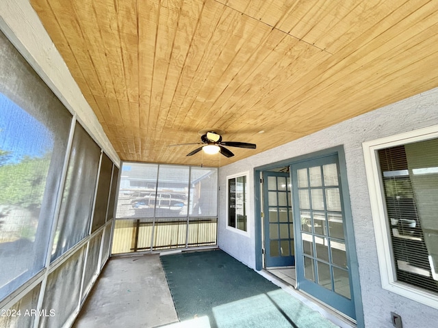 unfurnished sunroom with ceiling fan and wooden ceiling