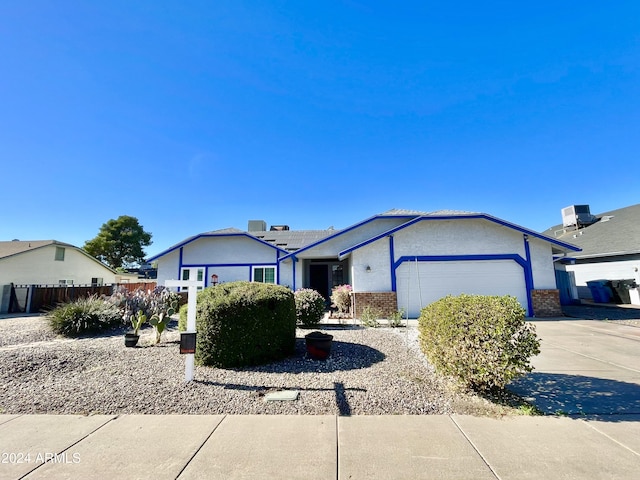 ranch-style home with cooling unit and a garage