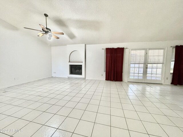 unfurnished living room featuring ceiling fan, light tile patterned floors, a textured ceiling, and french doors