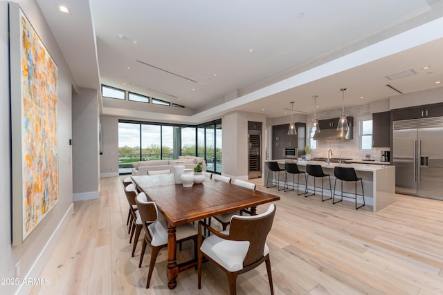 dining room with recessed lighting, a healthy amount of sunlight, baseboards, and light wood-style floors