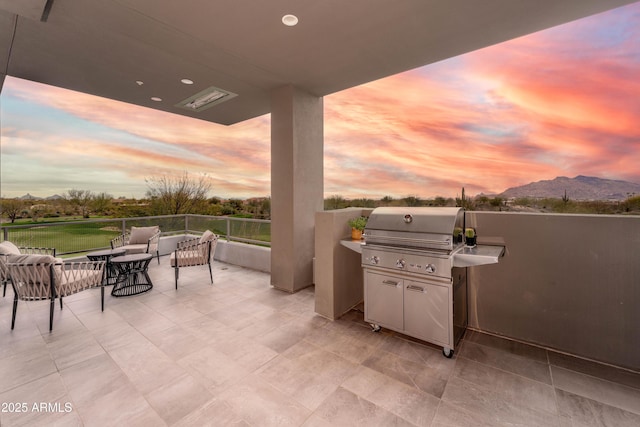 view of patio / terrace with a mountain view and a grill