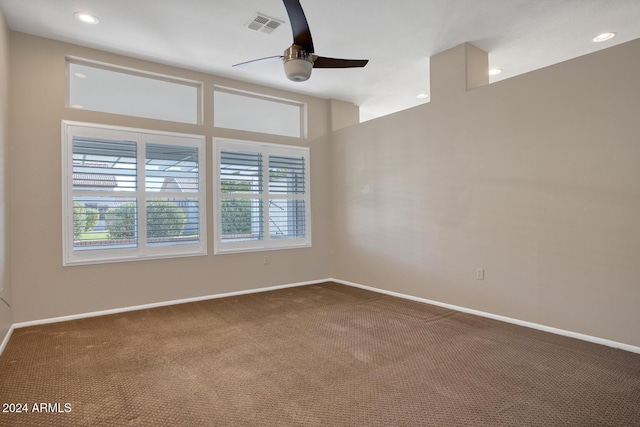 carpeted spare room with ceiling fan