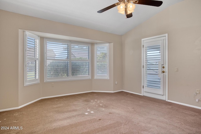 carpeted spare room featuring ceiling fan and vaulted ceiling