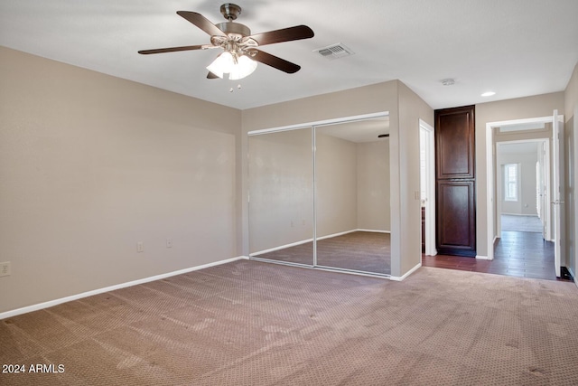 unfurnished bedroom featuring carpet floors, a closet, and ceiling fan