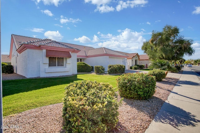 view of front of house featuring a garage and a front lawn