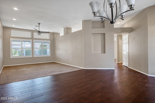 unfurnished room featuring ceiling fan with notable chandelier and dark wood-type flooring