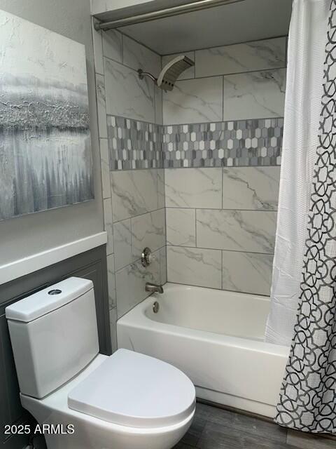 bathroom with wood-type flooring, toilet, and shower / tub combo