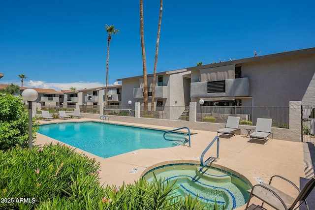 view of swimming pool featuring a patio area and a hot tub