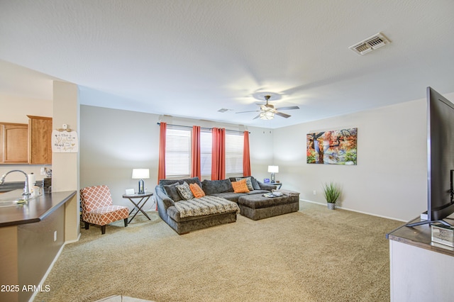living room with baseboards, ceiling fan, visible vents, and carpet
