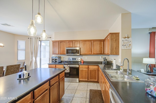 kitchen with pendant lighting, light tile patterned flooring, a sink, dark countertops, and stainless steel appliances