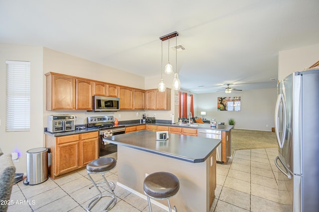 kitchen featuring a peninsula, a sink, stainless steel appliances, visible vents, and light tile patterned flooring