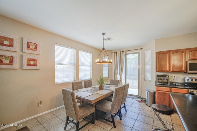 dining space with light tile patterned floors, baseboards, an inviting chandelier, and visible vents