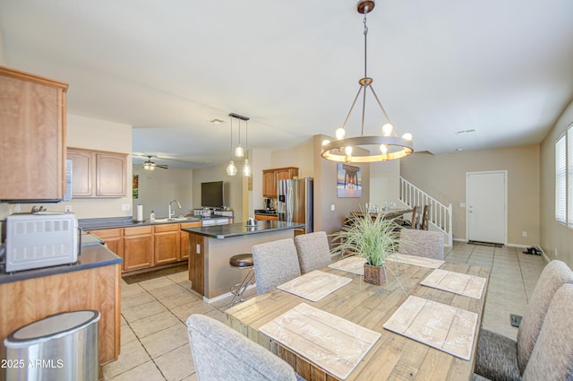 dining room with stairs, ceiling fan with notable chandelier, baseboards, and light tile patterned floors