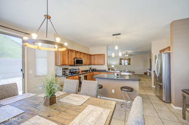 kitchen featuring brown cabinetry, a wealth of natural light, a peninsula, and appliances with stainless steel finishes