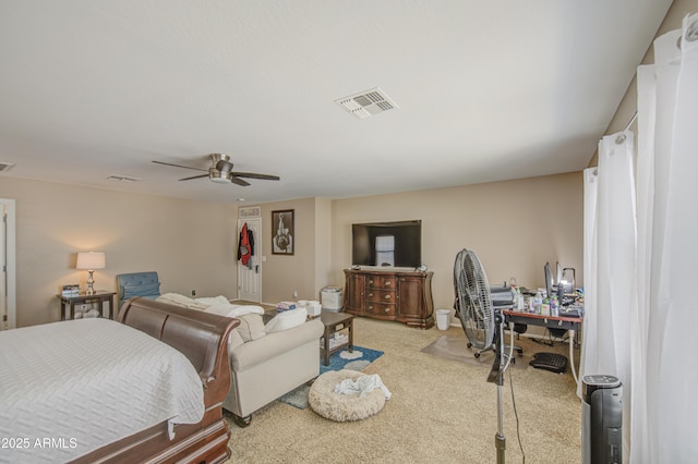 bedroom with light carpet, a ceiling fan, and visible vents